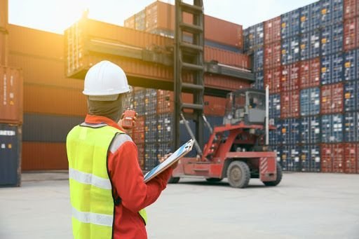 Opérateur logistique devant des conteneurs de marchandises